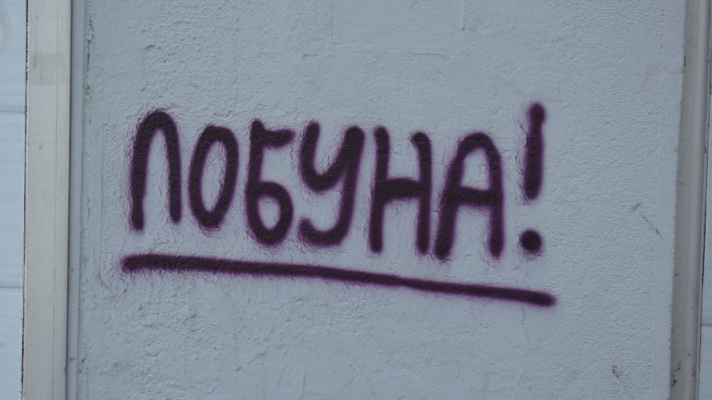 Graffiti says "pobuna!" on a wall.